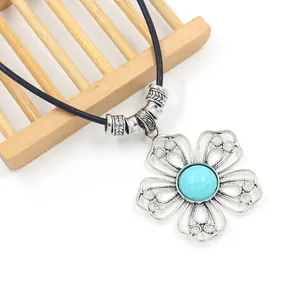 Detail of bohemian flower pendant with turquoise stone and carved silver beads