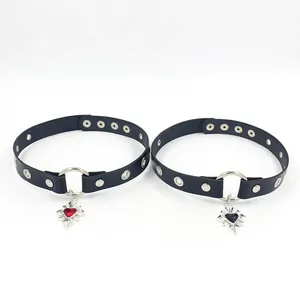 Detail of punk chokers featuring black leather, metal rivets, and heart cross pendants