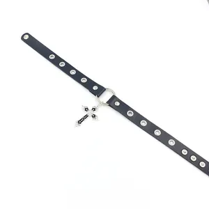 Gros plan du ras-du-cou en cuir noir avec pendentif croix vintage et rivets métalliques