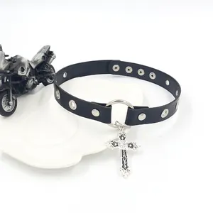 Choker en cuir noir punk avec pendentif croix argentée sur plateau blanc chic