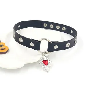 Detail of punk leather choker featuring metal rivets, a large O-ring and red heart pendant
