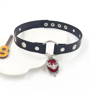 Gothic leather choker with red gem and silver bat pendant on a white decorative dish