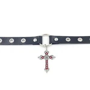 Détail d'un collier choker en cuir noir avec œillets argentés et pendentif croix rouge