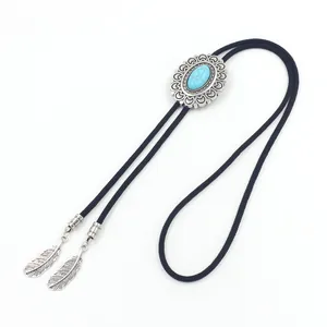 Detail of vintage bolo tie showing turquoise stone inlay and carved feather metal charms