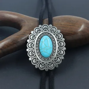 Macro view of vintage silver bolo tie slide featuring oval turquoise stone and metal carving