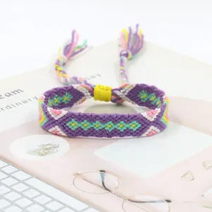 Macro shot of purple hand-woven friendship bracelet with colorful geometric patterns