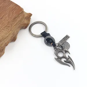 Close-up of vintage alloy flame totem charms on a black braided leather keychain