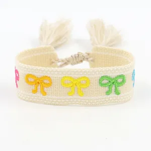 Ethnic embroidered friendship bracelet with colorful bow patterns and tassels