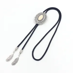 Detail of western bolo tie featuring silver feather charms and white stone slider
