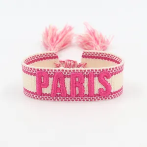 Colorful woven friendship bracelet featuring pink PARIS embroidery and soft tassels