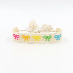 Close-up of woven friendship bracelet featuring colorful embroidered butterfly patterns