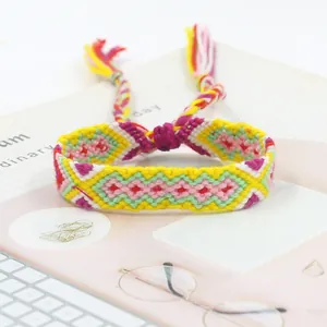 Close-up of handmade woven friendship bracelet with colorful geometric patterns and tassels