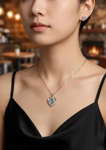 Gros plan d'un ensemble collier et boucles d'oreilles cœur en zircon bleu sur un modèle