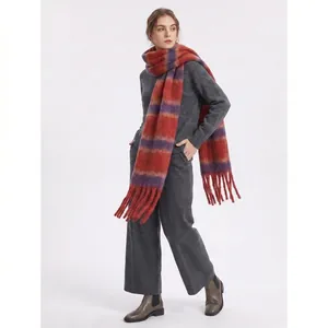 Thick striped scarf with tassels in red and purple tones shown on model in studio