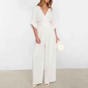 Detailed view of the deep V-neck and high-waisted pleated design on this elegant white jumpsuit