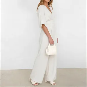Detail of white off-shoulder jumpsuit with high waist and elegant wide leg design