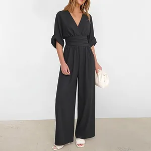 Detail of elegant black V-neck wide-leg jumpsuit with puff sleeves and layered waist