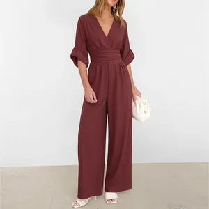 Detail of high-waist pleated bodice and wide-leg cut on burgundy women's jumpsuit