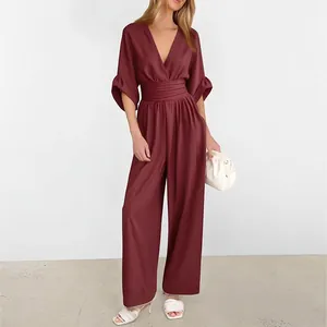 Detail of elegant deep burgundy jumpsuit featuring a deep V-neck and high-waisted wide legs