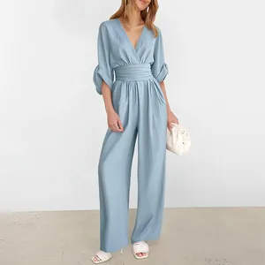 Detail of light blue off-shoulder jumpsuit with high waist and split cuff sleeves