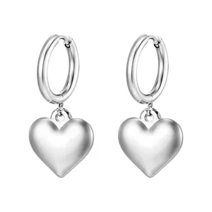 Detail view of silver heart drop earrings with polished finish on white background