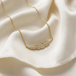 Collier élégant avec pendentif feuille dorée serti de cristaux sur soie blanche