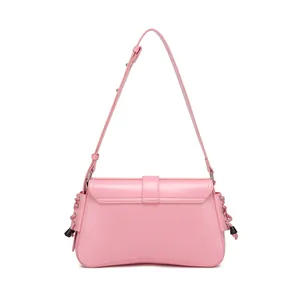 Detailed shot of pink leather baguette bag featuring adjustable strap and tassel accents