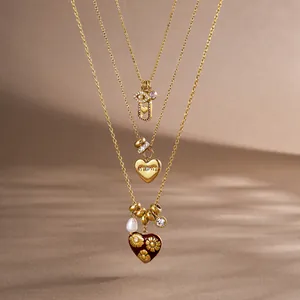 Detailed view of three-tiered gold stainless steel necklaces with Mom heart charms