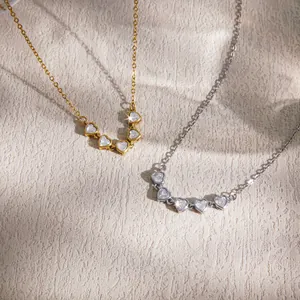 Close-up of gold and silver heart-shaped cubic zirconia necklaces on textured background