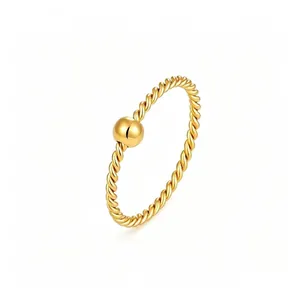 Primo piano di un elegante anello in oro a corda intrecciata con dettaglio di perla lucida