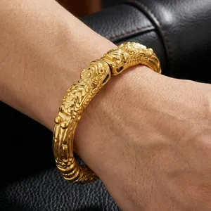 Detailed close-up of golden Pixiu bracelet with dragon scale texture on wrist