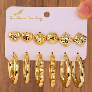 Detail of three pairs of gold-plated geometric earrings with a hammered metal texture