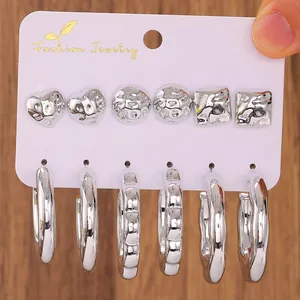 Detail of silver earring set with textured heart, square studs and hoop earrings