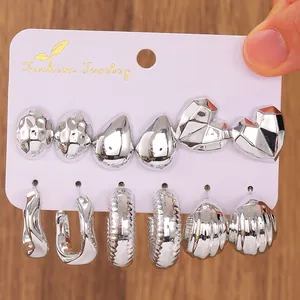 Set of 6 silver geometric C-shaped earrings with polished finish on display card