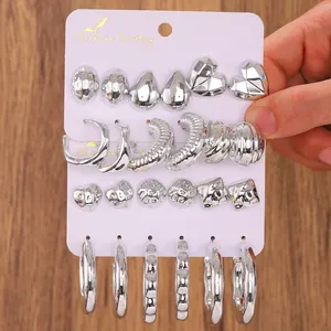 Close-up of silver vintage C-shape hoop earring set displayed on a white jewelry card