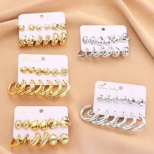 Detailed set of assorted gold and silver geometric earrings on a white jewelry card