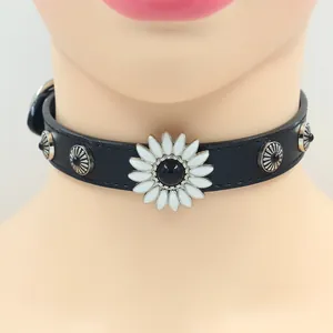 Close-up of black leather choker with white floral ornament and silver rivets on a model