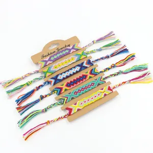 Set of seven colorful handmade woven friendship bracelets with tassels on card