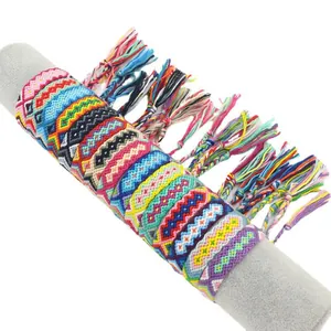Handmade woven friendship bracelets with colorful boho patterns and tassels on a display stand