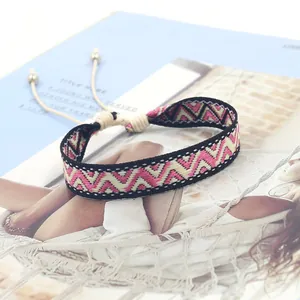 Close-up of bohemian woven bracelet with geometric sawtooth pattern on a magazine background