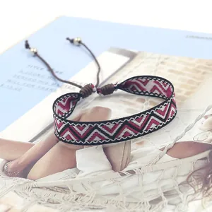 Detail of bohemian geometric pattern woven bracelet with adjustable cord and beads