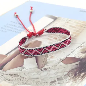 Close-up of bohemian hand-woven bracelet with red geometric patterns on a fashion magazine