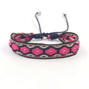 Détails de broderie sur bracelet bohème avec motifs floraux roses et cordon ajustable