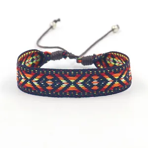 Gros plan des motifs géométriques d'un bracelet d'amitié ethnique tissé à la main coloré