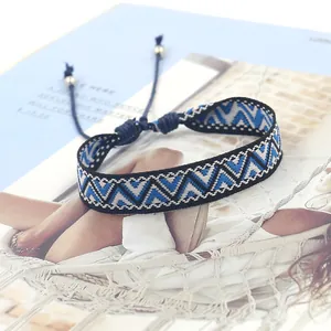 Close-up of blue and black bohemian woven friendship bracelet with geometric patterns