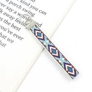 Detailed view of bohemian geometric diamond embroidery on fabric wristlet with silver clasp