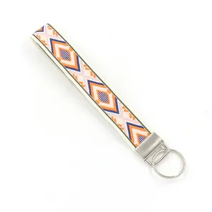 Bohemian geometric embroidered wrist strap keychain with silver metal clip on white background