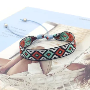 Detail of woven boho bracelet with geometric patterns and adjustable light blue cord