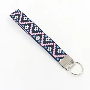 Llavero de pulsera bordado étnico con motivos geométricos y anilla de metal plateado