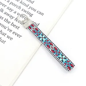 Detail of bohemian geometric embroidered woven wristlet with silver metal keyring clasp